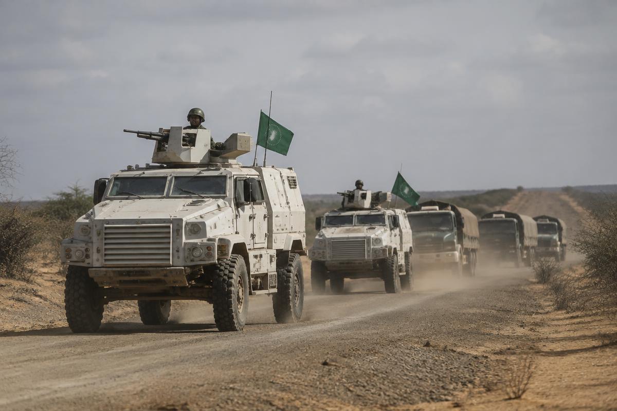 African Union armoured vehicles and logistics trucks on a dirt road in Somalia